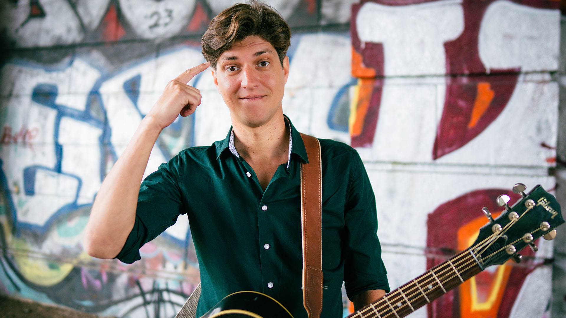 FALK mit Gitarre vor Graffitti-Wand