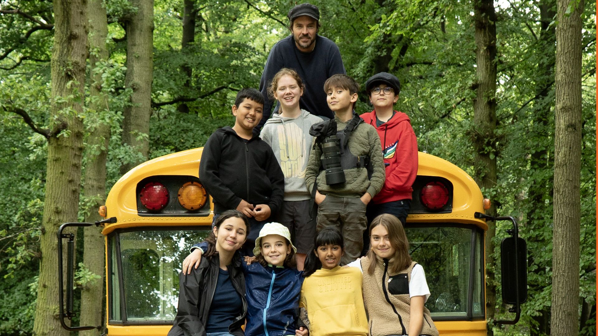 Die Protagonisten des Films "Future Council - Komm an Bord" rund um Regisseur Damon Gameau sitzen auf einem gelben Bus, der in einem grünen Wald steht.